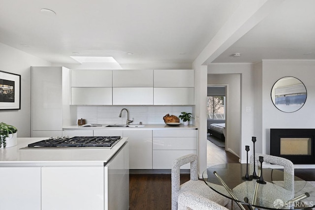 kitchen featuring a sink, modern cabinets, white cabinets, and light countertops