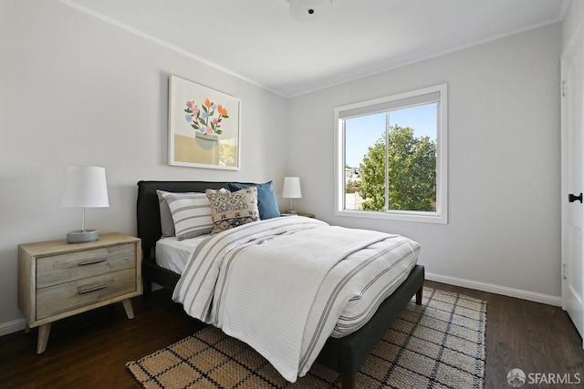 bedroom featuring dark wood finished floors, crown molding, and baseboards