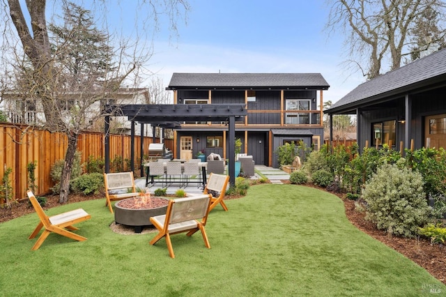 back of house featuring a balcony, a pergola, a lawn, and an outdoor living space with a fire pit