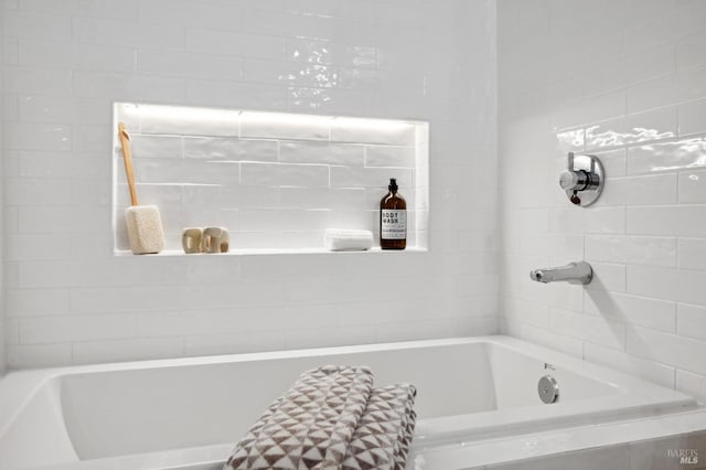 bathroom with a relaxing tiled tub