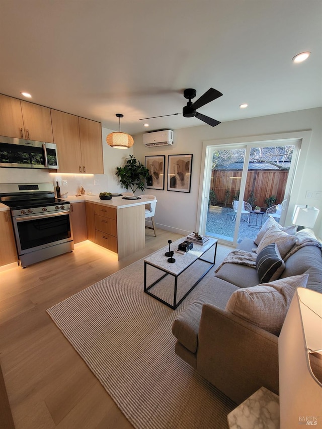 living room with light hardwood / wood-style floors, ceiling fan, and a wall mounted air conditioner