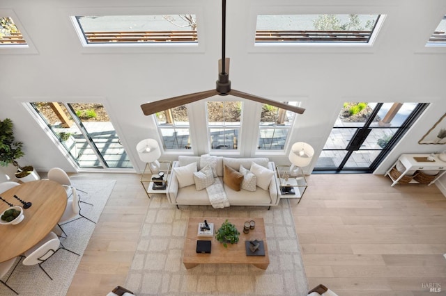 living room with a skylight and light hardwood / wood-style flooring