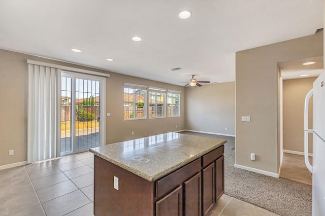 9877 Bluefin Way, Elk Grove, CA 95757 - kitchen featuring a ceiling fan, recessed lighting, dark brown cabinetry, a kitchen island, and light colored carpet