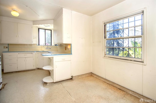 7520 Sunkist Dr, Oakland, CA 94605 - kitchen with open shelves, white cabinets, backsplash, and light countertops