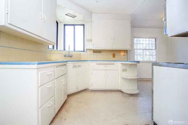7520 Sunkist Dr, Oakland, CA 94605 - kitchen featuring open shelves, white cabinetry, backsplash, and light countertops