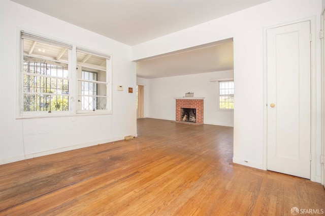 7520 Sunkist Dr, Oakland, CA 94605 - unfurnished living room with wood finished floors and a brick fireplace