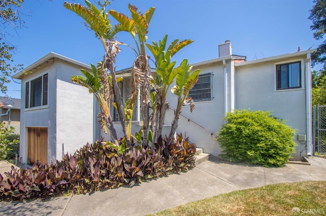 7520 Sunkist Dr, Oakland, CA 94605 - view of front of house featuring stucco siding and a chimney