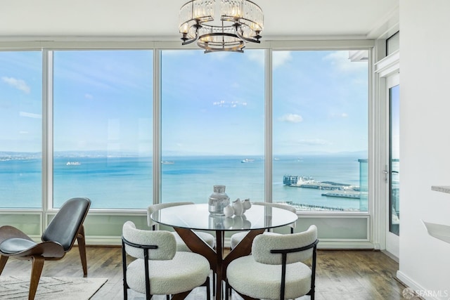 dining space featuring a wealth of natural light, a water view, and a chandelier