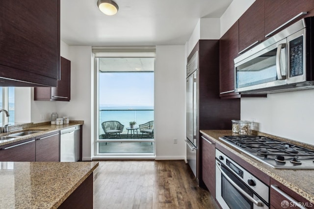 kitchen featuring dark wood-type flooring, a wealth of natural light, appliances with stainless steel finishes, and a sink