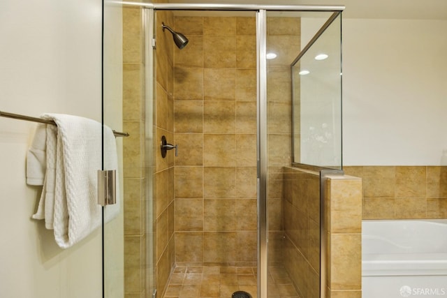 full bath featuring a shower stall and a garden tub