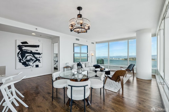 dining area featuring visible vents, a baseboard radiator, an inviting chandelier, dark wood-style flooring, and expansive windows