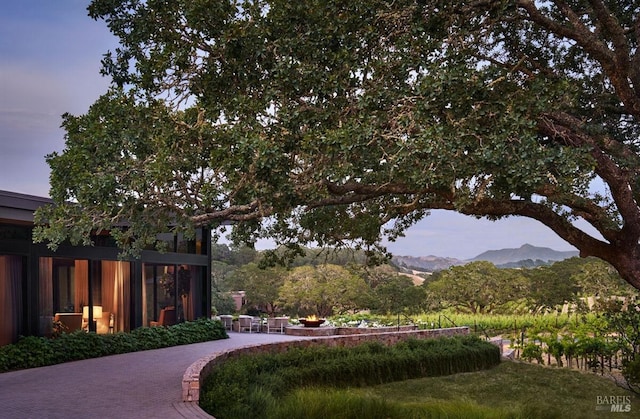 yard at dusk with a mountain view and a patio area