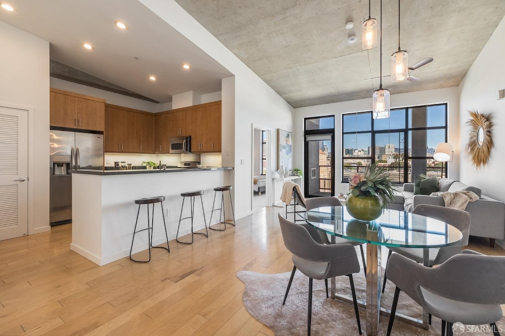 dining area featuring a wealth of natural light, lofted ceiling, and light hardwood / wood-style floors