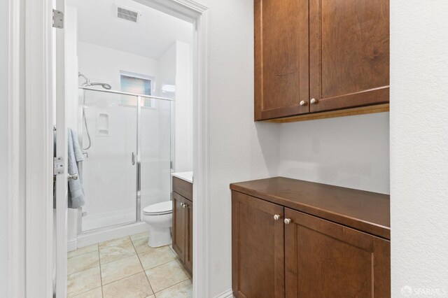 bathroom with walk in shower, tile patterned flooring, vanity, and toilet