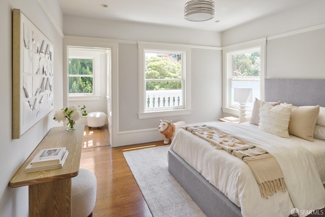 bedroom with light wood-style floors and multiple windows
