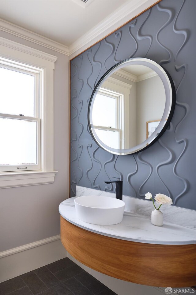 bathroom featuring ornamental molding, a wealth of natural light, and a sink