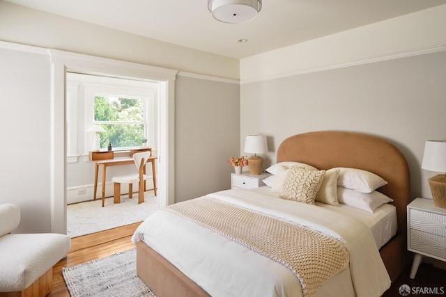 bedroom with baseboards and wood finished floors
