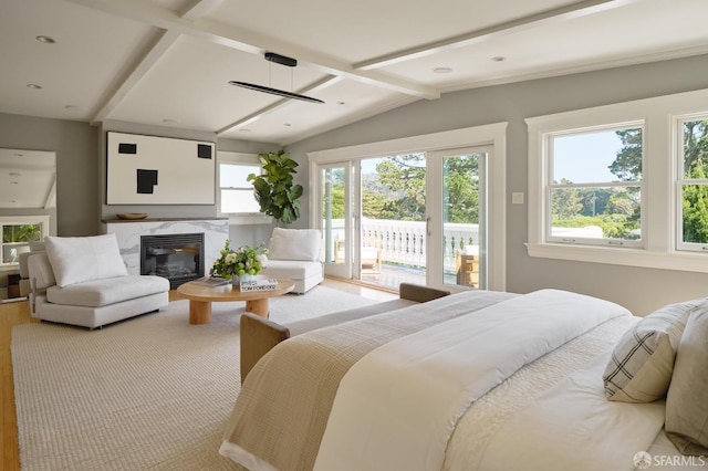 bedroom with a fireplace, wood finished floors, lofted ceiling with beams, and access to exterior