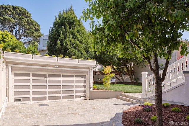 garage with fence and driveway