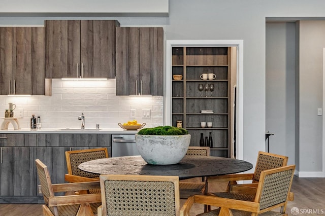 kitchen featuring hardwood / wood-style flooring, stainless steel dishwasher, sink, and decorative backsplash