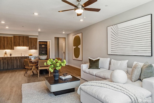 living room with light hardwood / wood-style flooring and ceiling fan