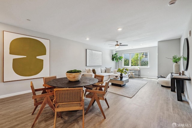 dining area with hardwood / wood-style floors and ceiling fan