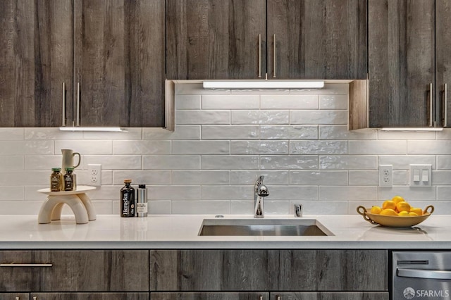 kitchen featuring sink, backsplash, and dark brown cabinetry