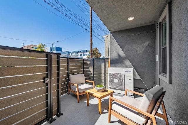 view of patio with ac unit and a balcony