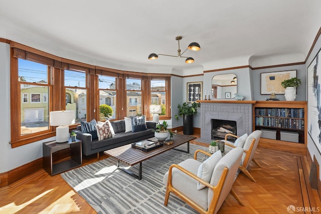 living room featuring an inviting chandelier, a tiled fireplace, and light parquet floors