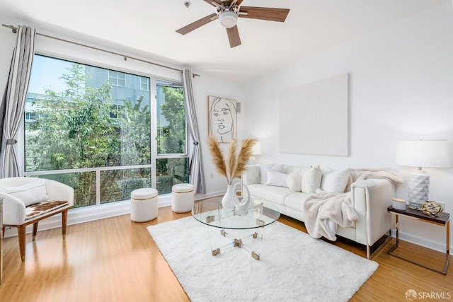 living room featuring ceiling fan, plenty of natural light, and wood-type flooring