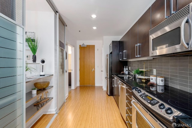 kitchen featuring sink, decorative backsplash, light wood-type flooring, appliances with stainless steel finishes, and dark brown cabinetry