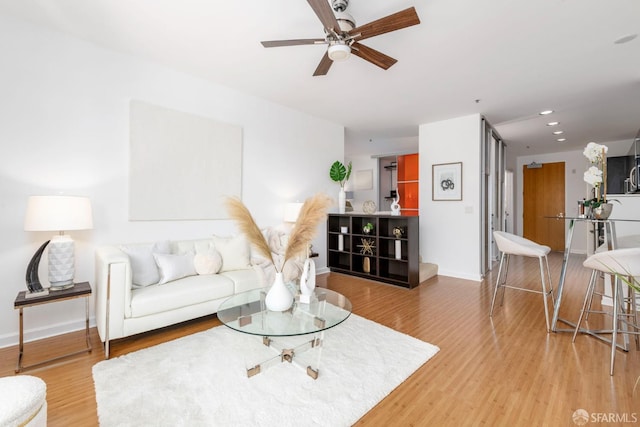 living room with ceiling fan and hardwood / wood-style flooring