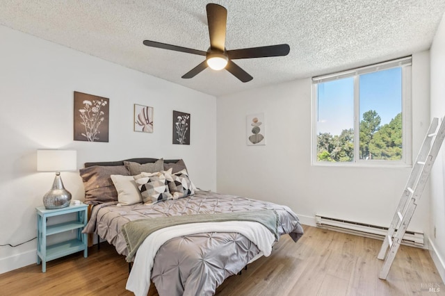 1333 N Camino Alto Unit 227, Vallejo, CA 94589 - bedroom with wood finished floors, a baseboard radiator, a textured ceiling, baseboards, and a ceiling fan