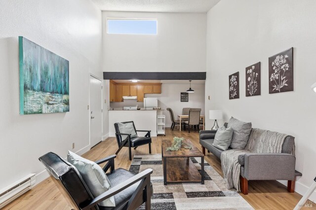 1333 N Camino Alto Unit 227, Vallejo, CA 94589 - living area with baseboard heating, a high ceiling, light wood finished floors, and baseboards