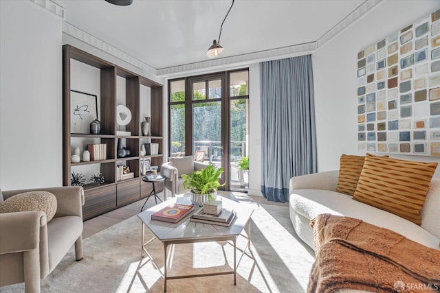 living room with ornamental molding and light hardwood / wood-style floors