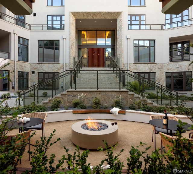 view of property's community featuring a fire pit and a patio area