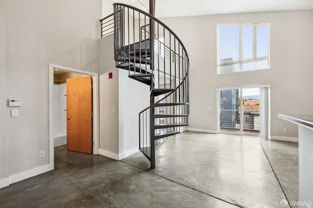 stairway with a high ceiling and concrete flooring