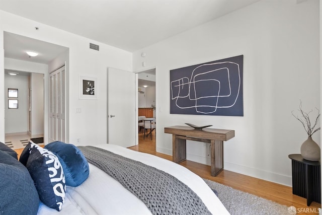 bedroom with wood-type flooring and a closet