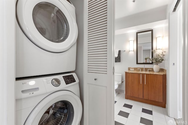 clothes washing area featuring stacked washer and dryer and sink