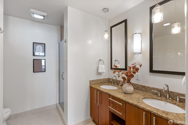 bathroom featuring vanity, toilet, tile patterned flooring, and a shower with door