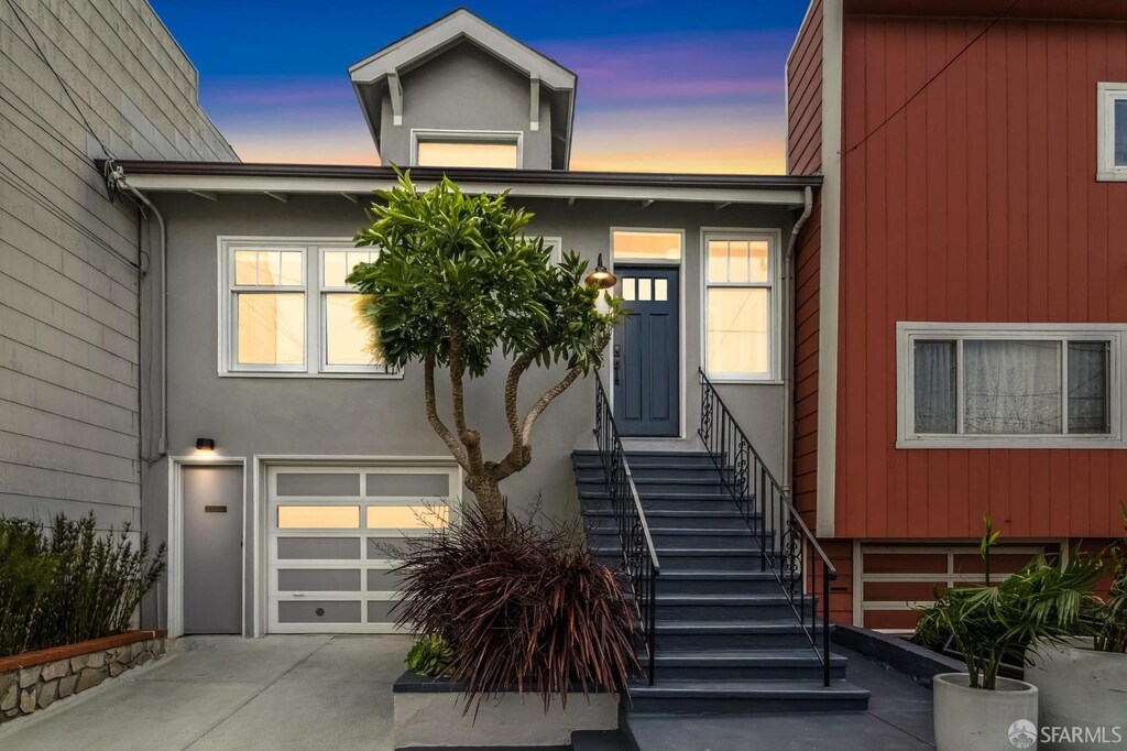 635 Moscow St, San Francisco, CA 94112 - view of front of house featuring a garage, concrete driveway, stucco siding, and stairway