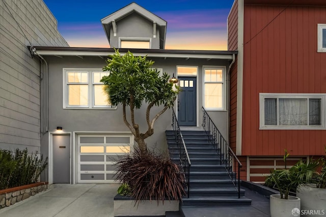 635 Moscow St, San Francisco, CA 94112 - view of front of house featuring a garage, concrete driveway, stucco siding, and stairway
