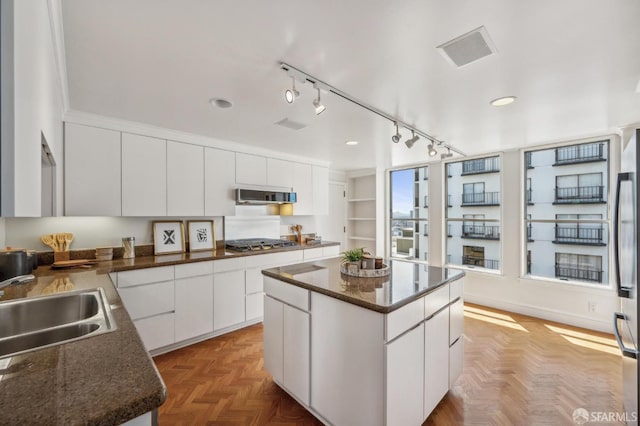 1220 Jones St Unit 601, San Francisco, CA 94109 - kitchen featuring a sink, stainless steel gas stovetop, extractor fan, a center island, and white cabinets