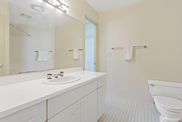 bathroom with tile patterned flooring, vanity, toilet, and a shower