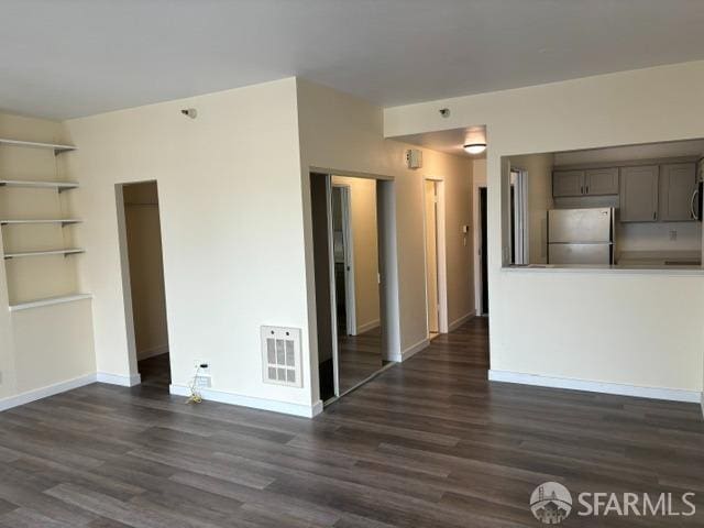 unfurnished room with built in features and dark hardwood / wood-style floors