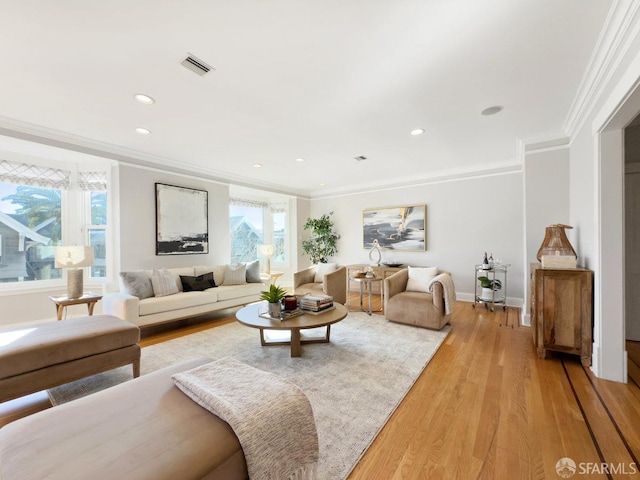 living room with ornamental molding and light hardwood / wood-style flooring