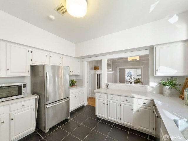 kitchen with white cabinetry, dark tile patterned flooring, and stainless steel appliances