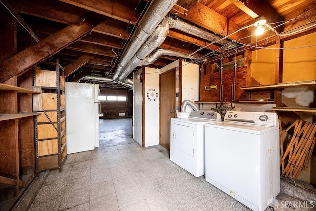 clothes washing area featuring washer and clothes dryer, laundry area, and tile patterned floors