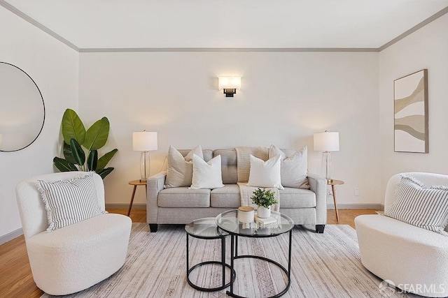 living room with light wood-style flooring, baseboards, and ornamental molding