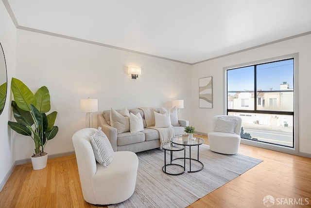 living room with crown molding, wood finished floors, and baseboards